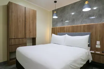 a bedroom with a white bed and a wooden headboard at Dasso 167 by Wynwood House in Lima