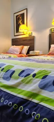 a bedroom with two beds with a green and white comforter at Hospedaje CASA REAL in Huancayo