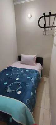 a small bedroom with a bed with a blue comforter at Hospedaje CASA REAL in Huancayo