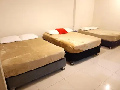 a room with three beds in a room at Centro Histórico de Lima, Departamentos Temporales in Lima