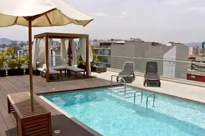 a swimming pool on top of a building with an umbrella at Miraflores Centre Boutique Apartment 101B in Lima
