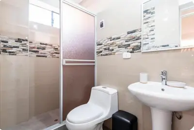 a bathroom with a toilet and a sink and a shower at Casa Monacó in Cusco