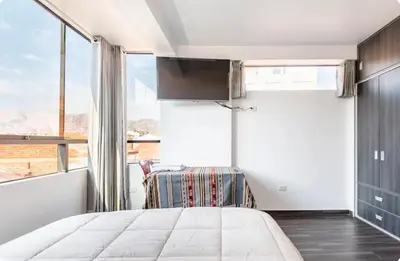 a bedroom with a bed and a large window at Casa Monacó in Cusco