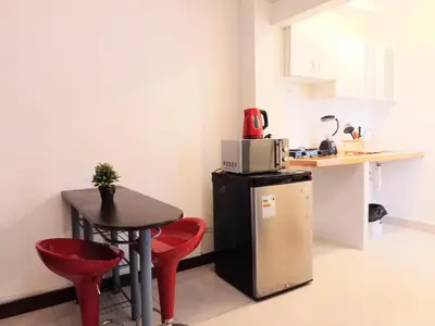 a small kitchen with a small table and red chairs at Departamentos Céntricos en Lima in Lima