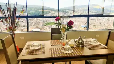 a table with vases of flowers on it with a view at Hathun House in Cusco