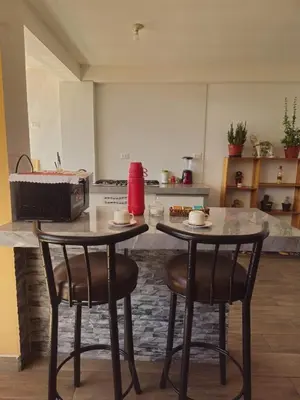 a kitchen with two tables and two chairs in a kitchen at Hathun House in Cusco