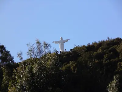 a white cross on top of a hill with trees at Hotel Montecristo Cusco in Cusco