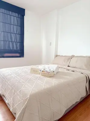 a white bed with a basket on top of it at Apartamento moderno y céntrico en Lima, 3 Dormitorios in Lima