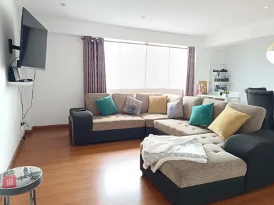 a living room with a couch and a tv at Apartamento moderno y céntrico en Lima, 3 Dormitorios in Lima