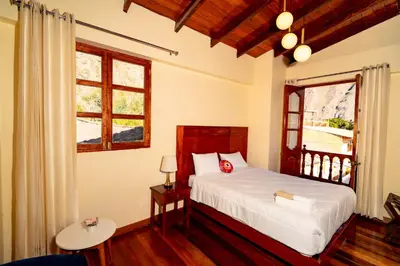 a bedroom with a bed and a window at NUNA SUMAQ Hotel in Ollantaytambo