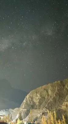 a starry night with a mountain in the background at NUNA SUMAQ Hotel in Ollantaytambo