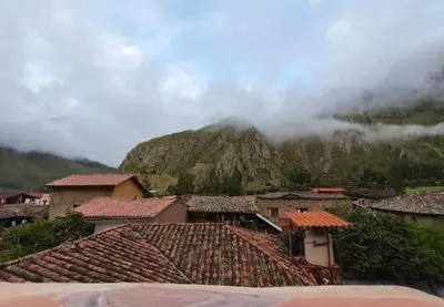 a group of houses in front of a mountain at NUNA SUMAQ Hotel in Ollantaytambo