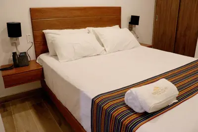 a bedroom with a large white bed with a telephone at Ribera del Rio Club Resort in Cieneguilla