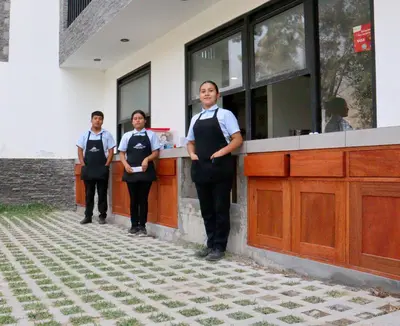 a group of three people standing in front of a counter at Ribera del Rio Club Resort in Cieneguilla