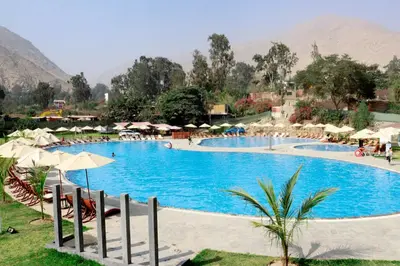a large swimming pool with umbrellas and a resort at Ribera del Rio Club Resort in Cieneguilla