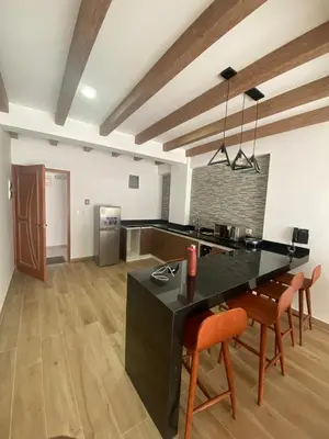 a large kitchen with a black counter and orange chairs at Ribera del Rio Club Resort in Cieneguilla