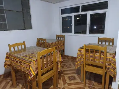 a dining room with two tables and chairs and a window at Hostal Cielo Azul in Canta