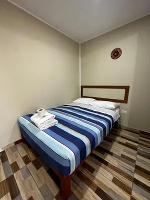 a bedroom with a bed with towels on it at Hotel Eli House in Nazca