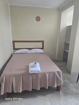 a bedroom with a bed with two towels on it at Hotel Eli House in Nazca