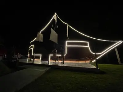 two people standing in front of a building with lights at MONTEVERDIA - Hotel & Resort in Pozuzo