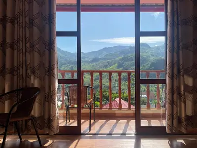 a room with a balcony with a view of the mountains at MONTEVERDIA - Hotel & Resort in Pozuzo