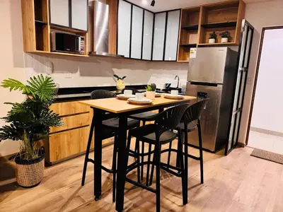 a kitchen with a table and chairs and a refrigerator at MONTERRICO POLO APARTS #17 - Dpto de estreno con Balcón Frente Embajada USA in Lima