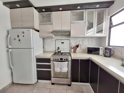 a kitchen with white cabinets and a stove and refrigerator at Modern 1-Bedroom Apartment with WiFi in Miraflores in Lima