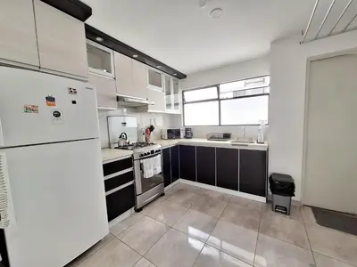 a kitchen with white appliances and a large window at Modern 1-Bedroom Apartment with WiFi in Miraflores in Lima