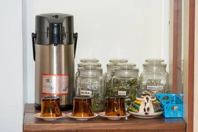 a shelf with jars and a thermos and a coffee maker at Conquistador Hotel in Cusco