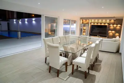 a dining room with a glass table and white chairs at CA3 - Casa de Lujo, Fiesta y Piscina - Punta hermosa in Punta Hermosa