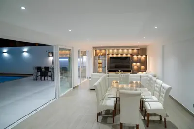 a living room with white furniture and a dining room at CA3 - Casa de Lujo, Fiesta y Piscina - Punta hermosa in Punta Hermosa