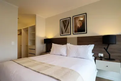 a bedroom with a white bed with two pictures on the wall at Liven in Miraflores by Wynwood House in Lima