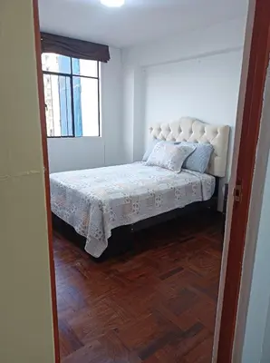 a bedroom with a bed in a room with a window at Alojamientos Perú II in Lima