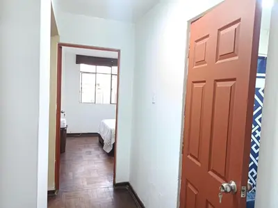 a hallway with a door and a room with a bed at Alojamientos Perú II in Lima