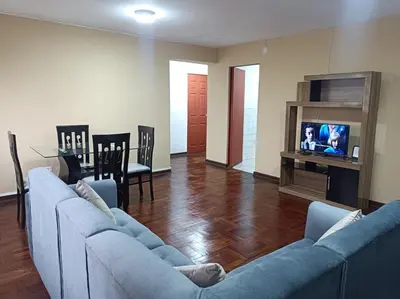 a living room with two blue couches and a television at Alojamientos Perú II in Lima