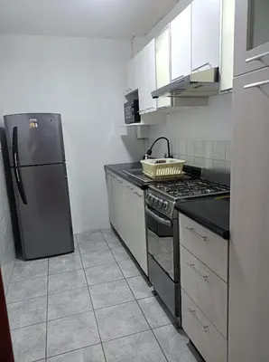 a kitchen with a stove and a refrigerator at Alojamientos Perú II in Lima