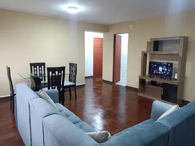 a living room with two blue couches and a television at Alojamientos Perú II in Lima