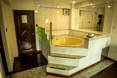 a large bathroom with a tub and a mirror at Hotel Lexus in Lima