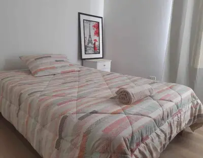 a bed with a striped comforter in a bedroom at Lily House in Ica