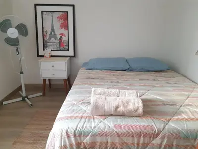 a bedroom with a bed and a floor fan at Lily House in Ica
