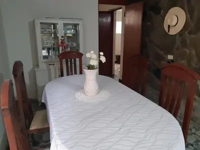 a dining room table with a vase with flowers on it at Lily House in Ica