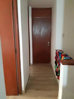 a hallway with a brown door and a wooden floor at Lily House in Ica