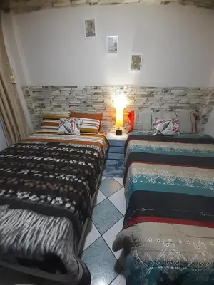 two beds in a room with a stone wall at Just for me in Lima