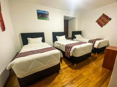a room with three beds in a room at Encanto de Concevidayoc in Cusco