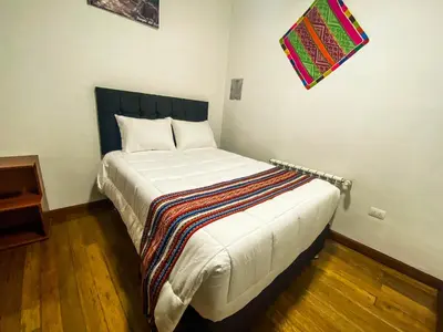 a bedroom with a bed with a blanket on it at Encanto de Concevidayoc in Cusco