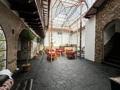 a patio with tables and chairs in a building at Encanto de Concevidayoc in Cusco