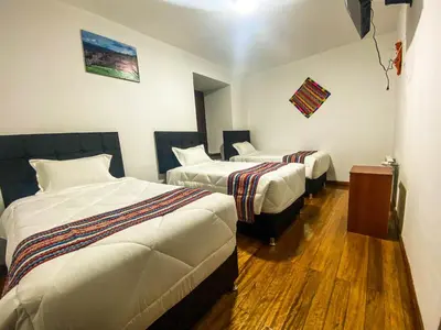 a hotel room with two beds in a room at Encanto de Concevidayoc in Cusco