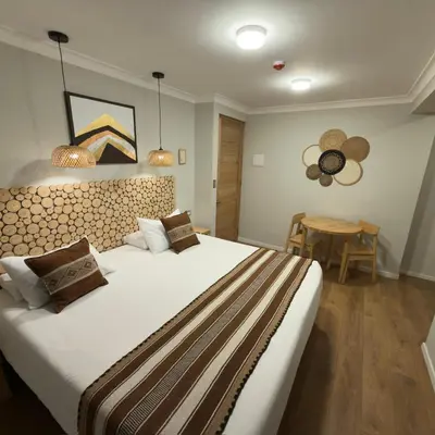 a bedroom with a large bed and a table at CASA CRISTOBAL Centenario in Cusco
