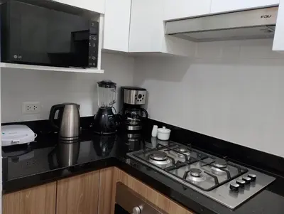 a kitchen with a stove top and a microwave at Departamento Pardo Miraflores in Lima