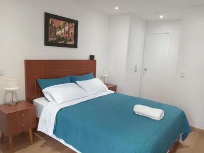 a bedroom with a large bed with a blue blanket at Departamento Pardo Miraflores in Lima